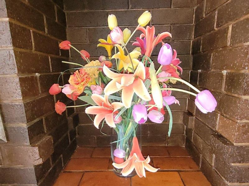 A close-up view of a brick fireplace hearth featuring a decorative floral arrangement.