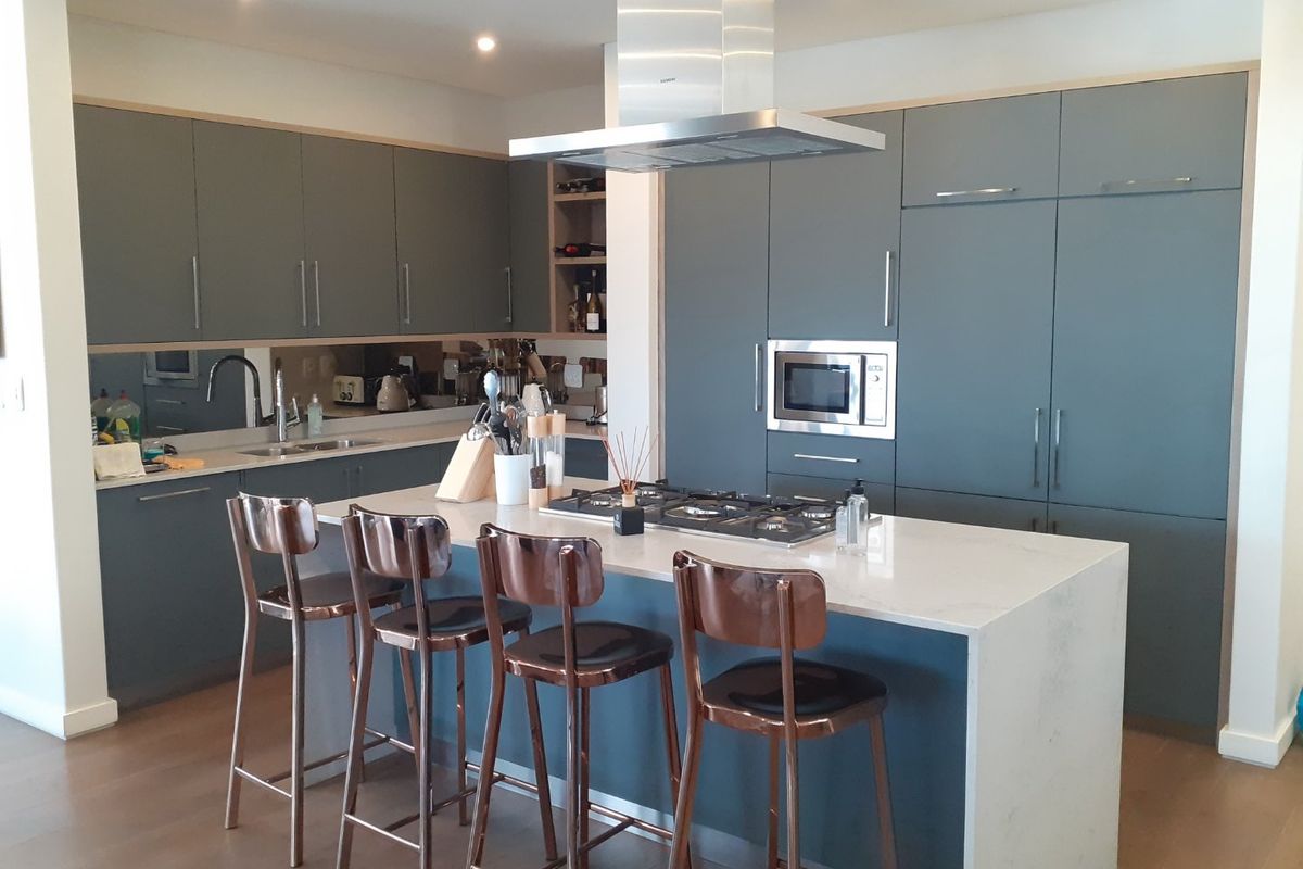 Modern kitchen featuring a central island with a gas hob, integrated appliances, sleek cabinetry, and high-quality quartz countertops.