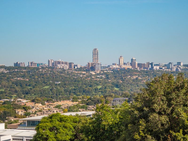 A clear, elevated panoramic view of the city skyline and surrounding suburban landscape.