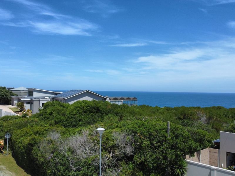 A scenic elevated view overlooking the coastal landscape and the ocean, showcasing the property's prime location and natural surroundings.