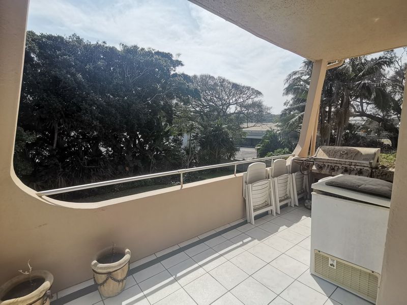 First floor corner unit with wrap around balcony and slight sea view through the trees - Photo 3