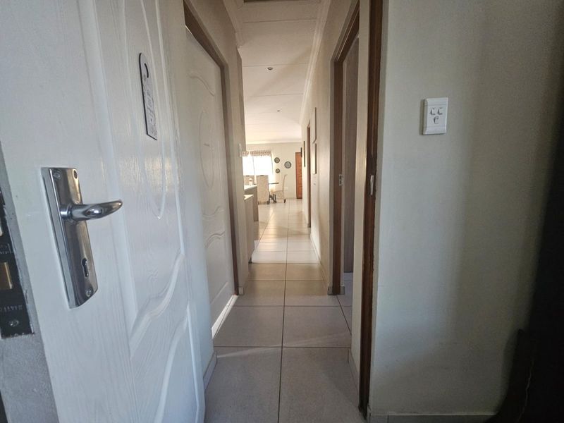 A view down a tiled hallway connecting multiple rooms within the home.