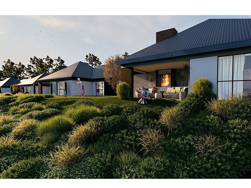 A rear view of a modern house featuring a covered patio with a built-in fireplace, overlooking a landscaped garden.