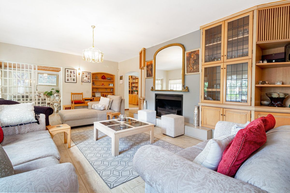 Spacious living room featuring a fireplace, built-in wooden cabinetry, and tiled flooring, offering a comfortable and traditional living space.