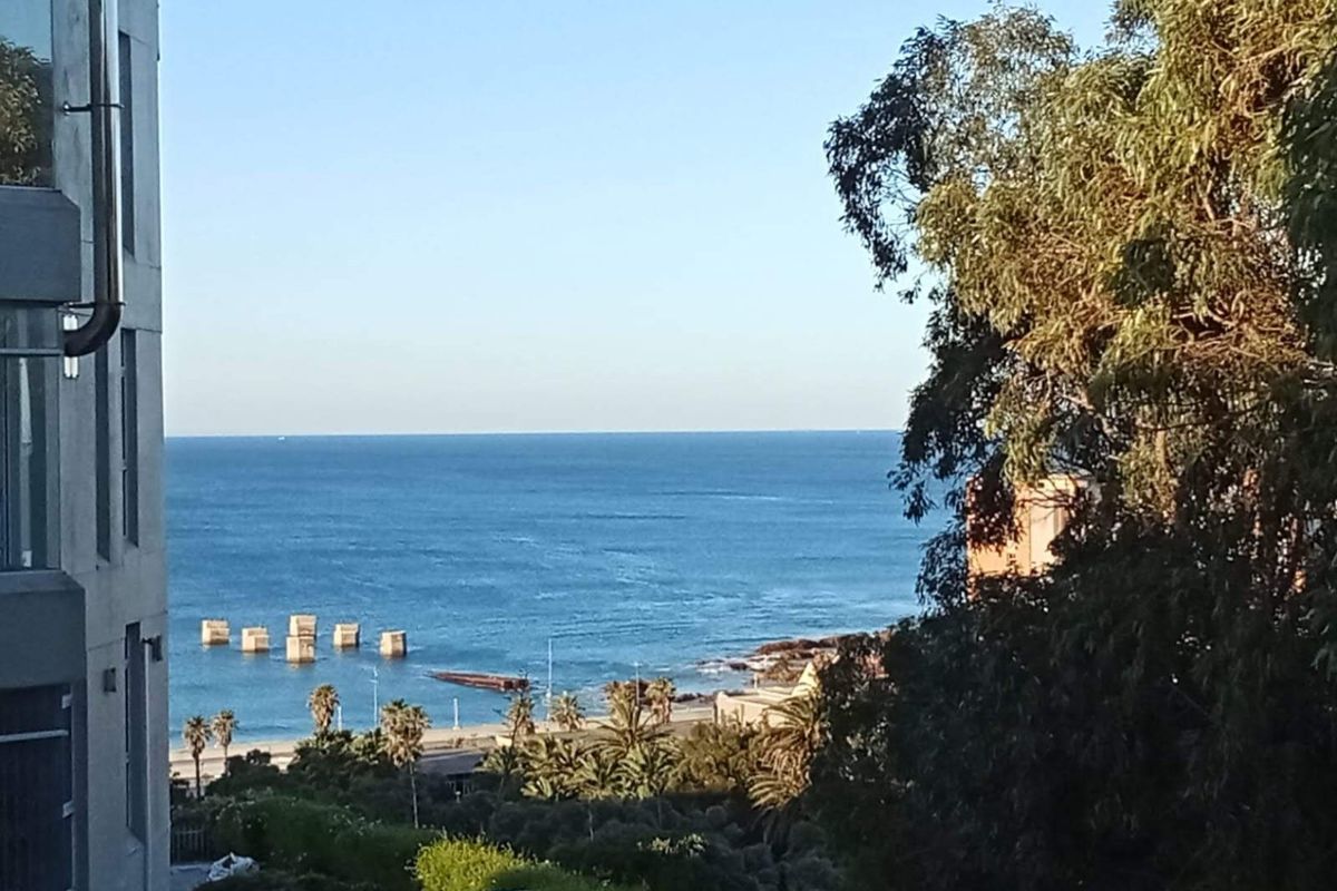 A scenic elevated view overlooking the ocean, coastline, and surrounding greenery, capturing the natural beauty of the coastal location.