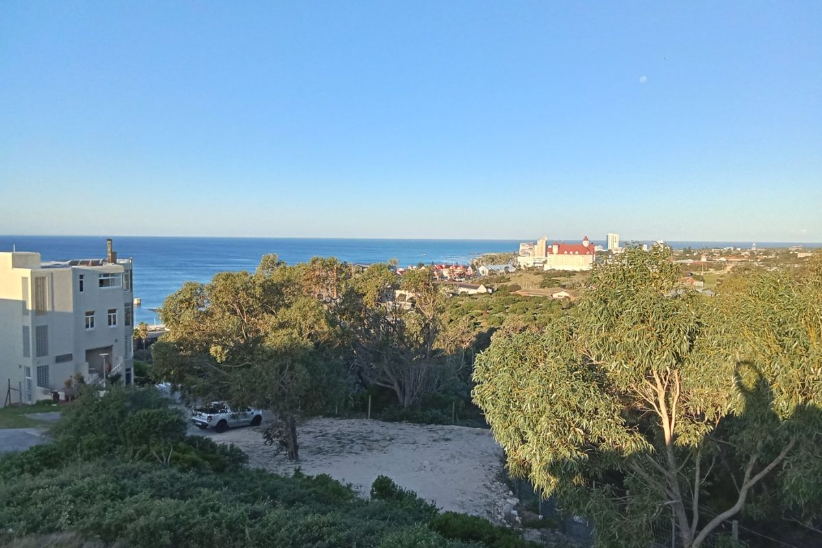 A scenic elevated view overlooking the coastal landscape, surrounding neighborhood, and the ocean horizon.