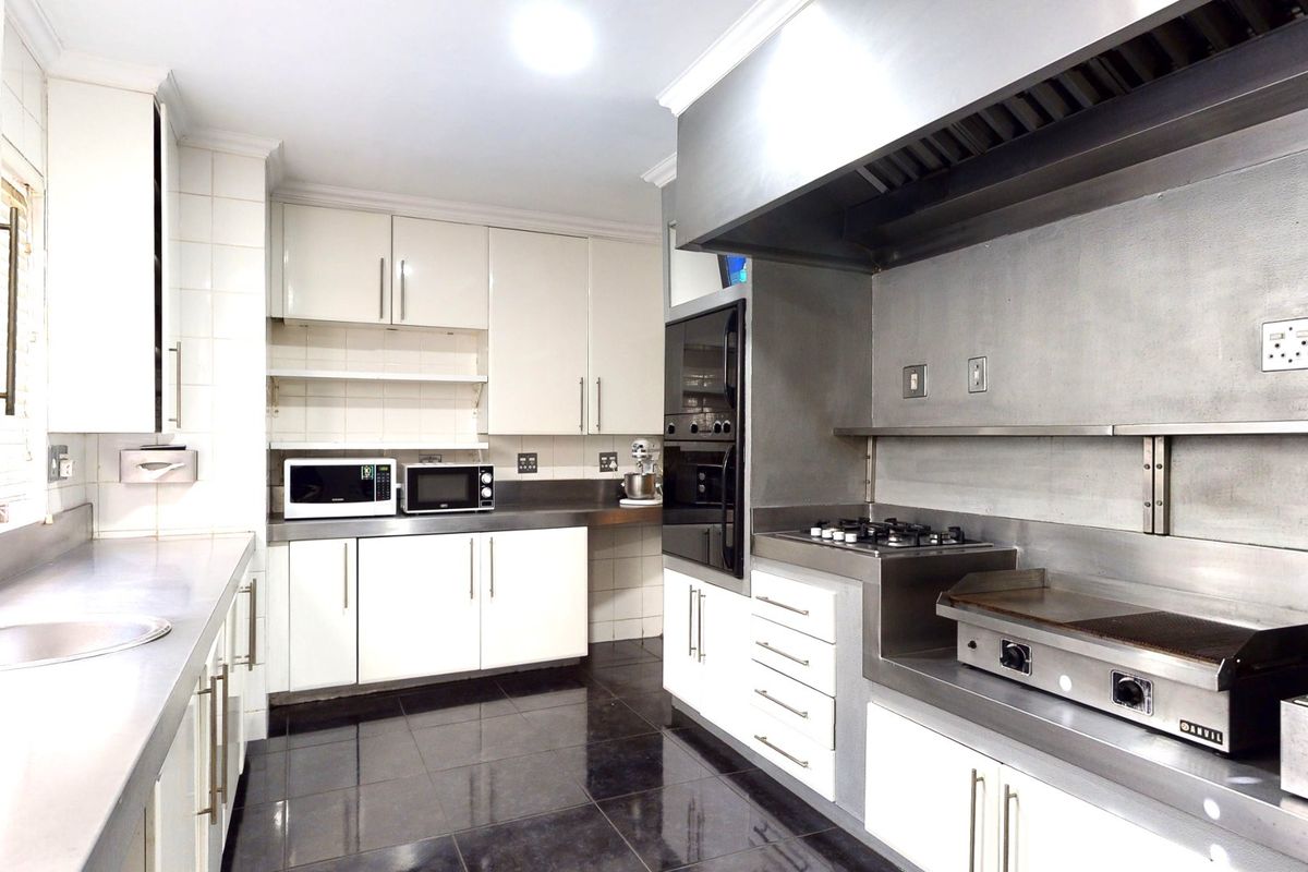 A professional-grade kitchen featuring stainless steel countertops, commercial-style gas cooktop, integrated oven, and ample cabinetry, ideal for serious home cooking.