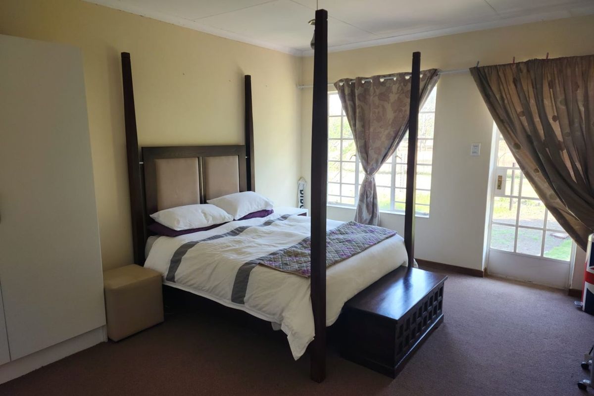 A bedroom featuring carpet flooring, a built-in wardrobe, and direct access to the exterior through a glass pane door.