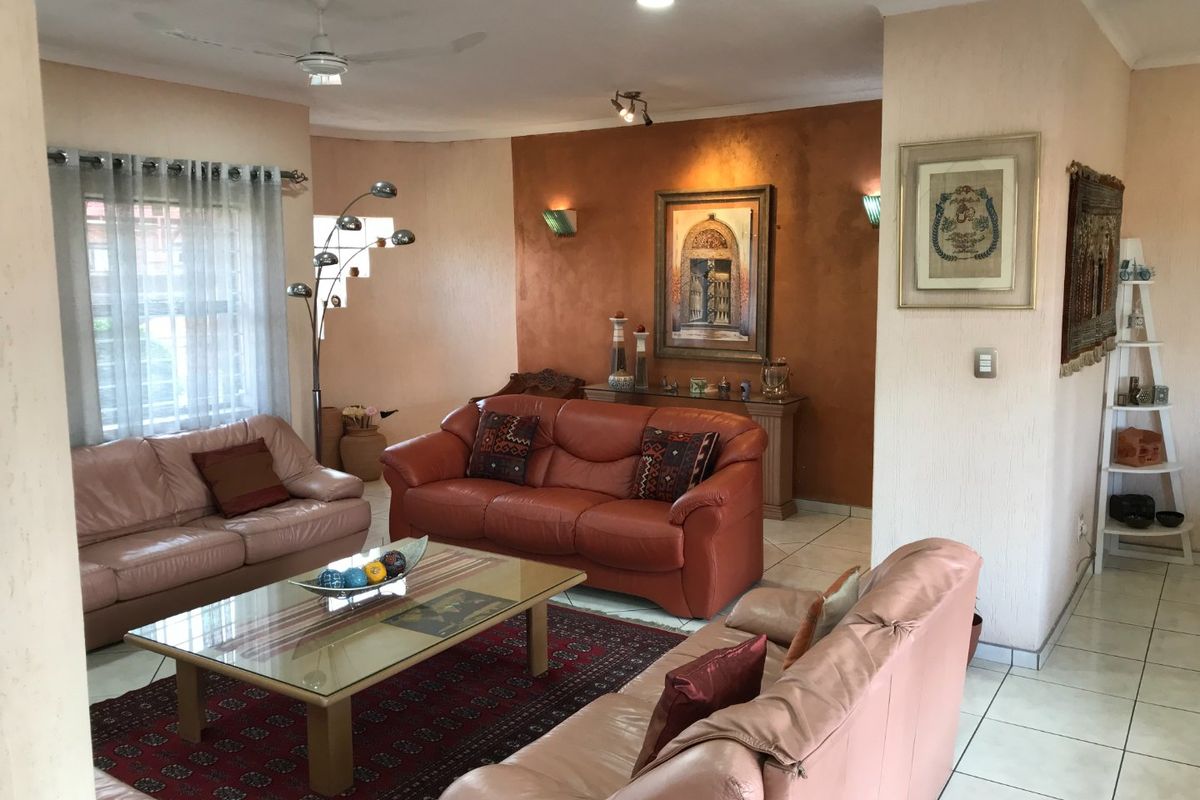 Spacious living room featuring tiled flooring, recessed lighting, a ceiling fan, and a textured accent wall.