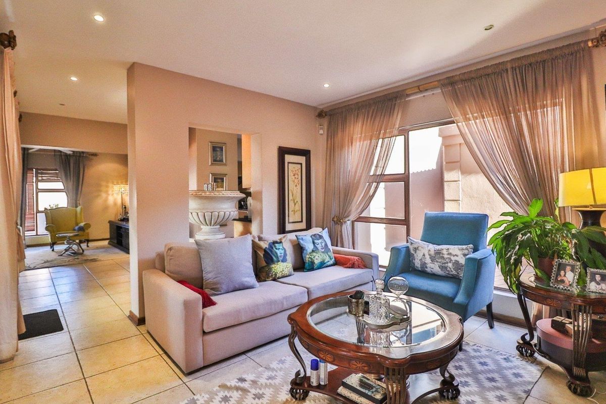 A comfortable living room featuring tiled flooring, recessed lighting, and large glass doors that provide natural light and access to the outdoor area.
