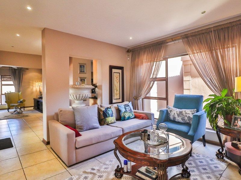 A comfortable living room featuring tiled flooring, recessed lighting, and large glass doors that provide natural light and access to the outdoor area.