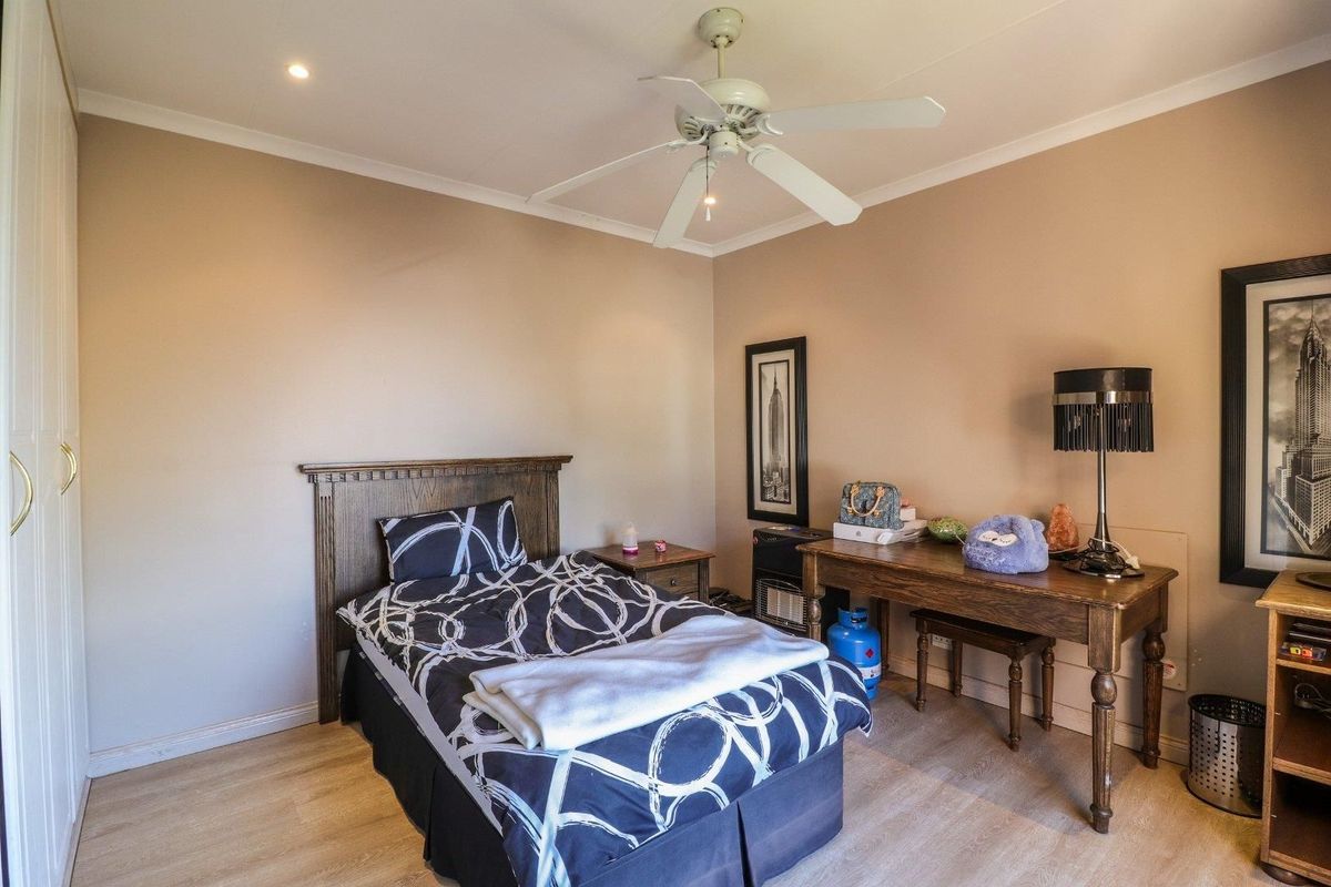 A well-maintained bedroom featuring laminate flooring, a ceiling fan, recessed lighting, and built-in wardrobe storage.