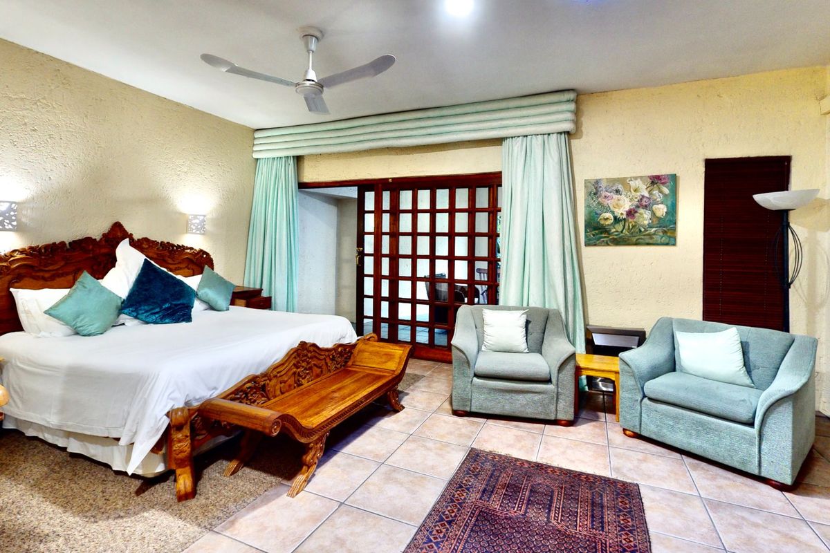 Spacious bedroom featuring tiled flooring, a ceiling fan, and sliding glass doors leading to an outdoor area.