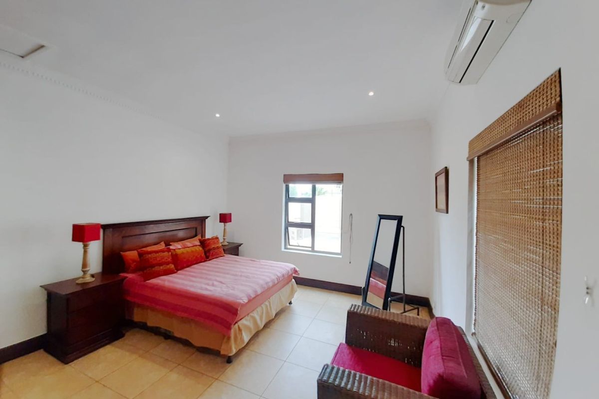 Spacious bedroom featuring tiled flooring, recessed lighting, and a wall-mounted split-system air conditioner for climate control.