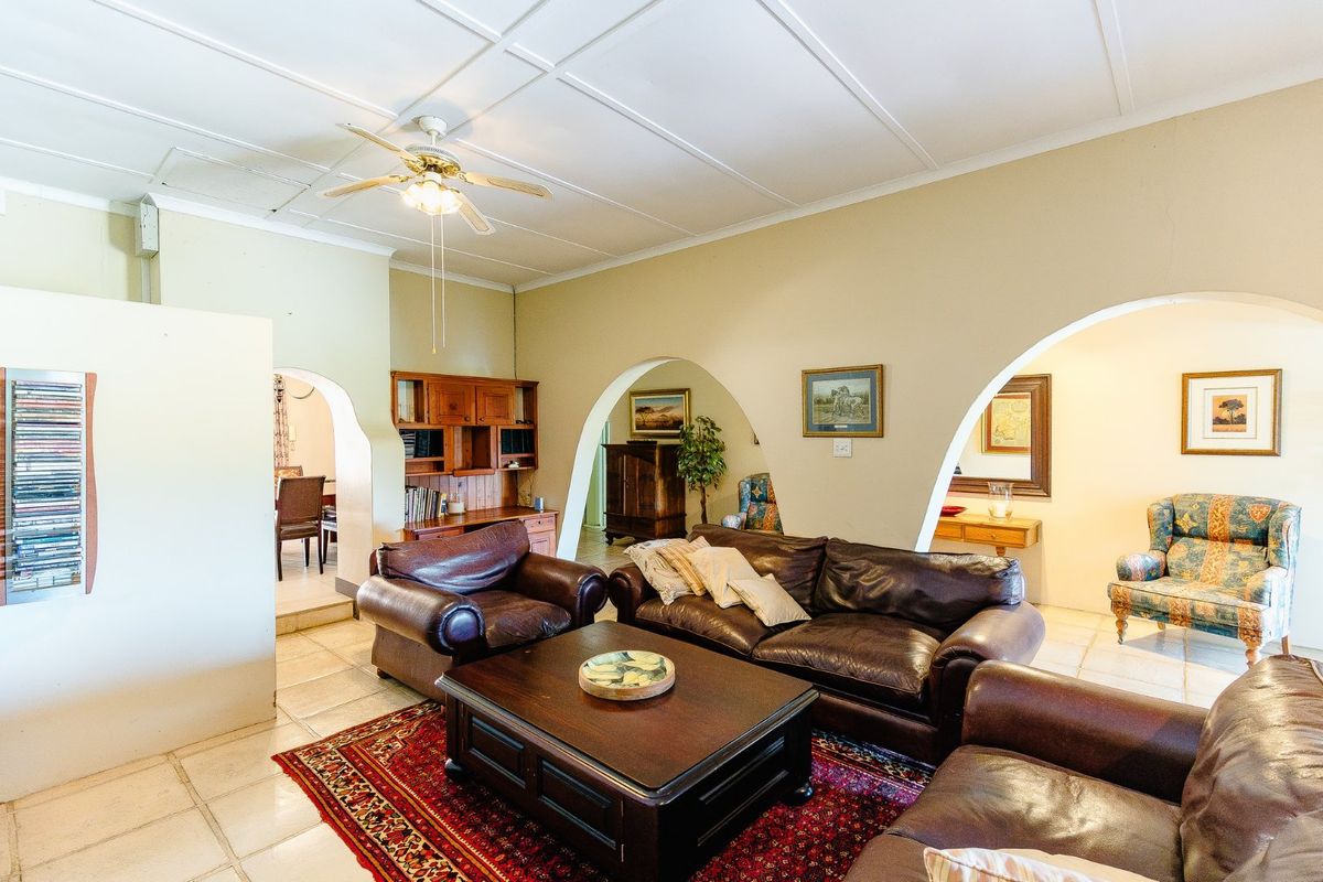 Spacious living area featuring distinctive arched doorways, tiled flooring, and a coffered ceiling, creating an open and connected layout.