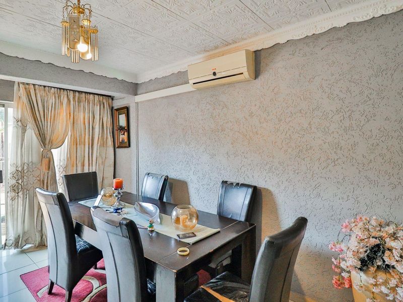 Dining area featuring textured walls, decorative ceiling tiles, and a split-system air conditioner, with direct access to an outdoor patio through sliding glass doors.