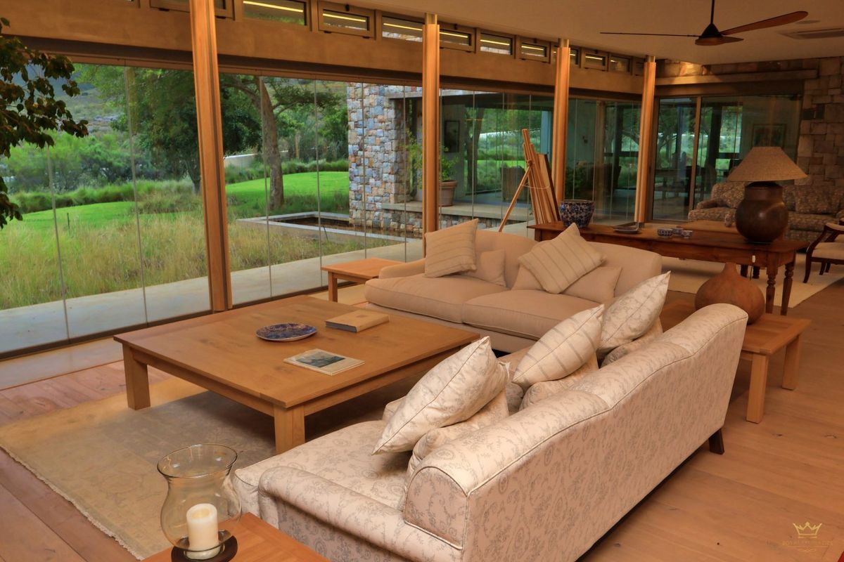 Spacious living area featuring floor-to-ceiling glass walls that provide seamless indoor-outdoor flow and expansive views of the surrounding farm landscape.