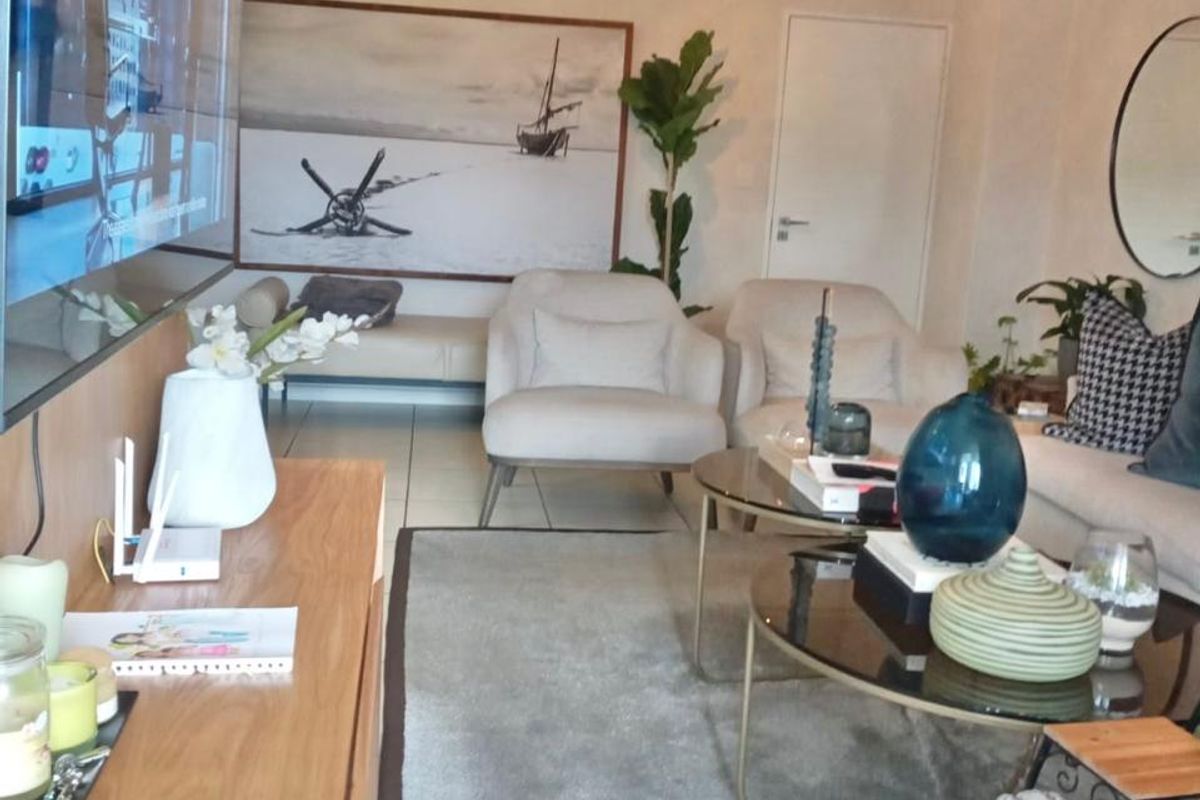 A well-maintained living room featuring tiled flooring, modern pendant lighting, and a neutral color palette, creating a comfortable and inviting atmosphere.