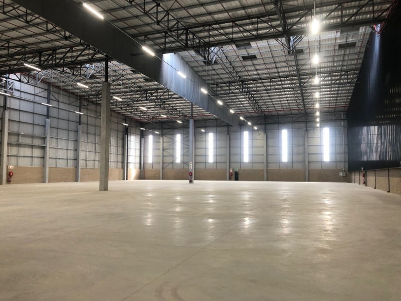 Spacious industrial warehouse featuring high-clearance ceilings, polished concrete floors, and efficient high-bay lighting, suitable for logistics or manufacturing operations.