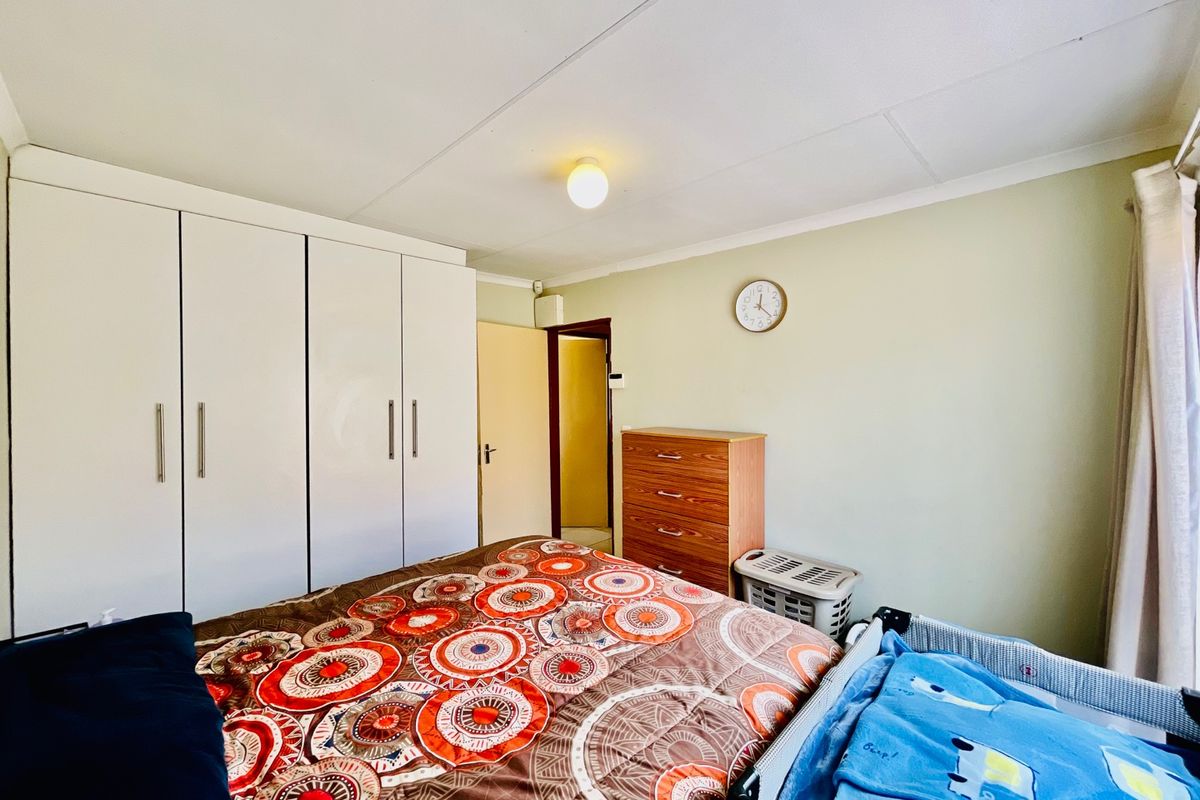A functional bedroom featuring built-in white cabinetry and a standard ceiling light fixture.