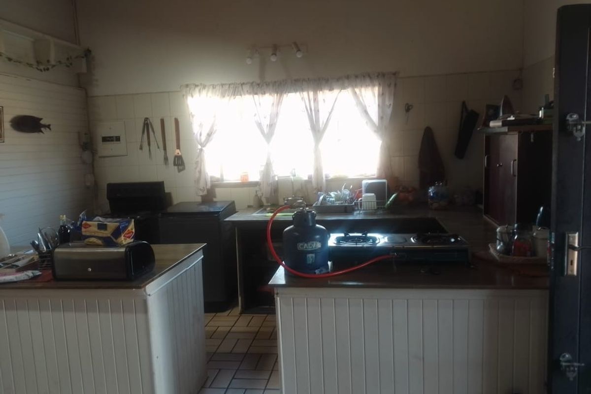 A dated kitchen featuring tiled flooring, built-in cabinetry, and a tiled splashback, requiring modernization to improve functionality and aesthetic appeal.