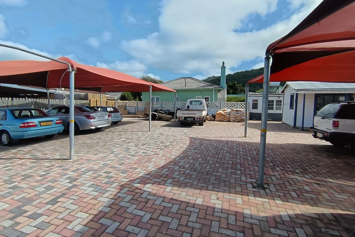 Commercial parking area featuring paved surfacing and multiple shade cloth carports for vehicle protection.