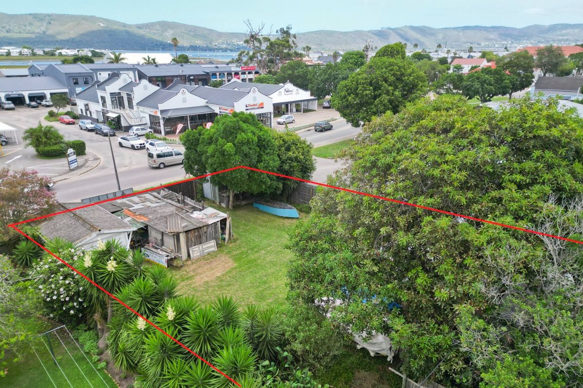 Aerial view of a commercial property plot featuring mature trees, boundary fencing, and a dilapidated outbuilding structure in a central urban location.