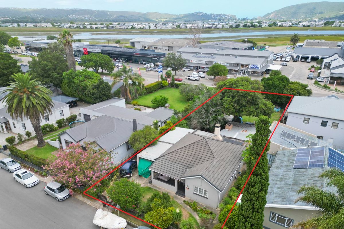 Aerial view of the commercial property highlighting the building structure, roof, garden area, and surrounding neighborhood context.