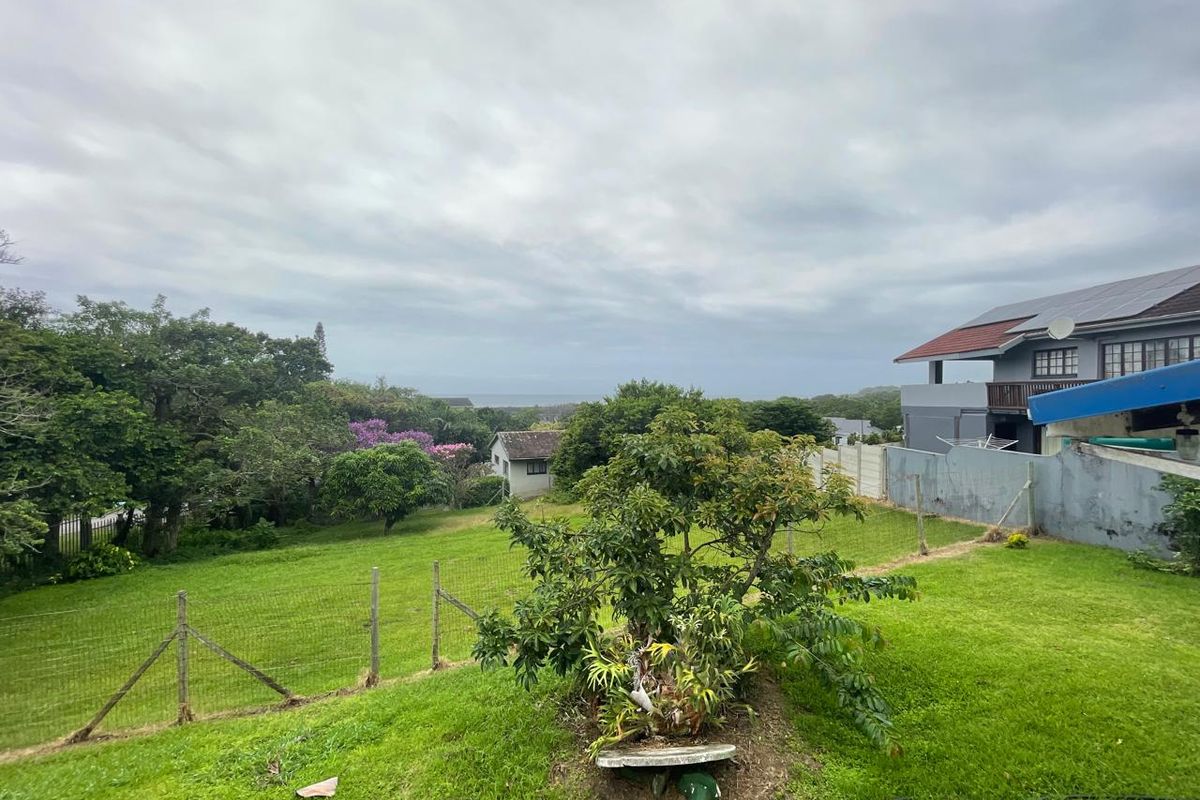 A spacious residential plot featuring established greenery, mature trees, and partial views, offering a peaceful setting for potential development.