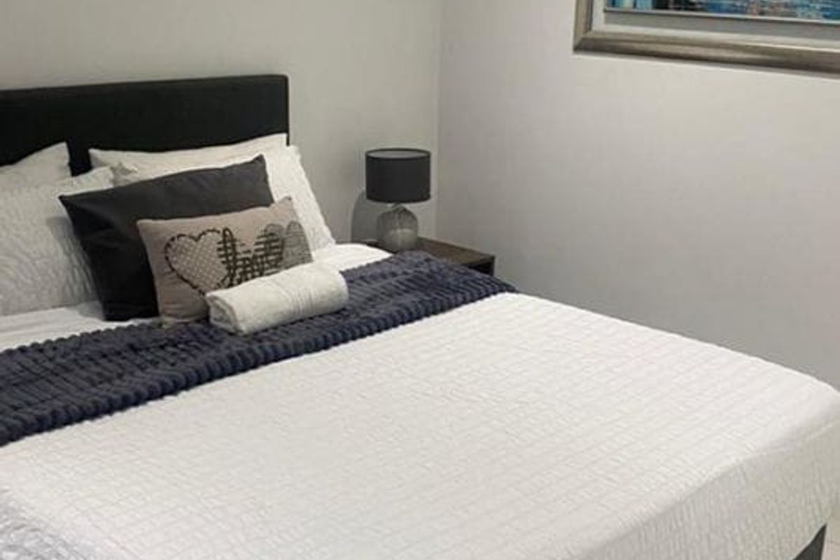 A well-maintained bedroom featuring neutral wall finishes and clean tiled flooring, providing a comfortable and functional living space.