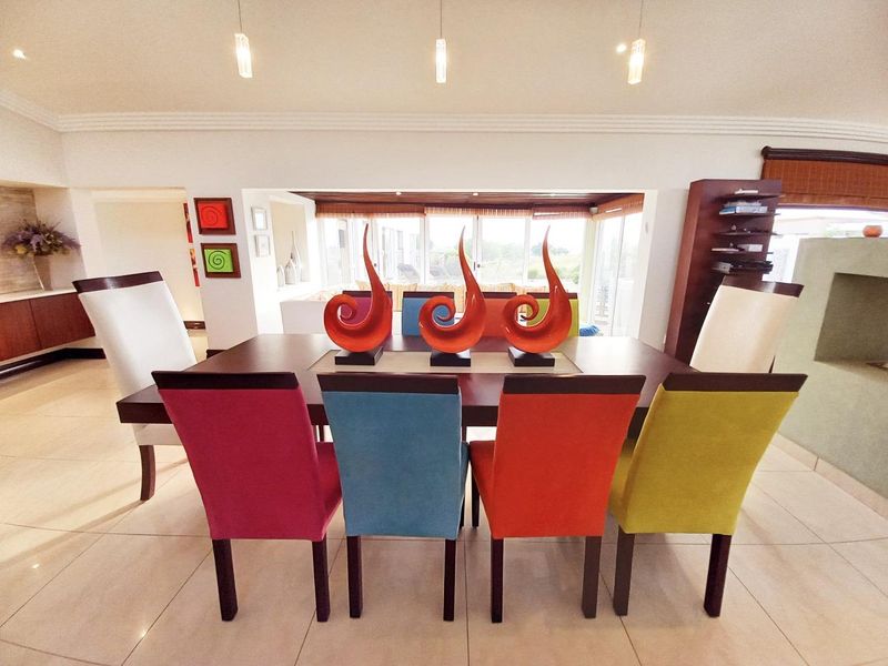 A bright dining area featuring tiled floors, recessed lighting, and direct access to an outdoor space through sliding glass doors.