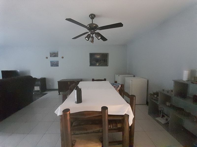 A dining area featuring tiled flooring and a central ceiling fan, providing a functional space for meals.