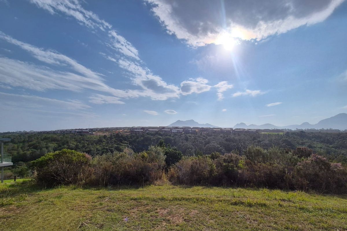 A scenic landscape view overlooking natural vegetation and distant mountains, showcasing the property's elevated position and surroundings.