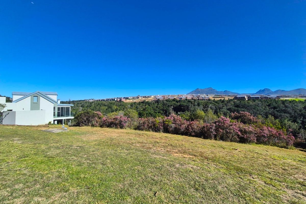 A scenic view of the surrounding landscape, rolling hills, and distant mountains from the residential property.