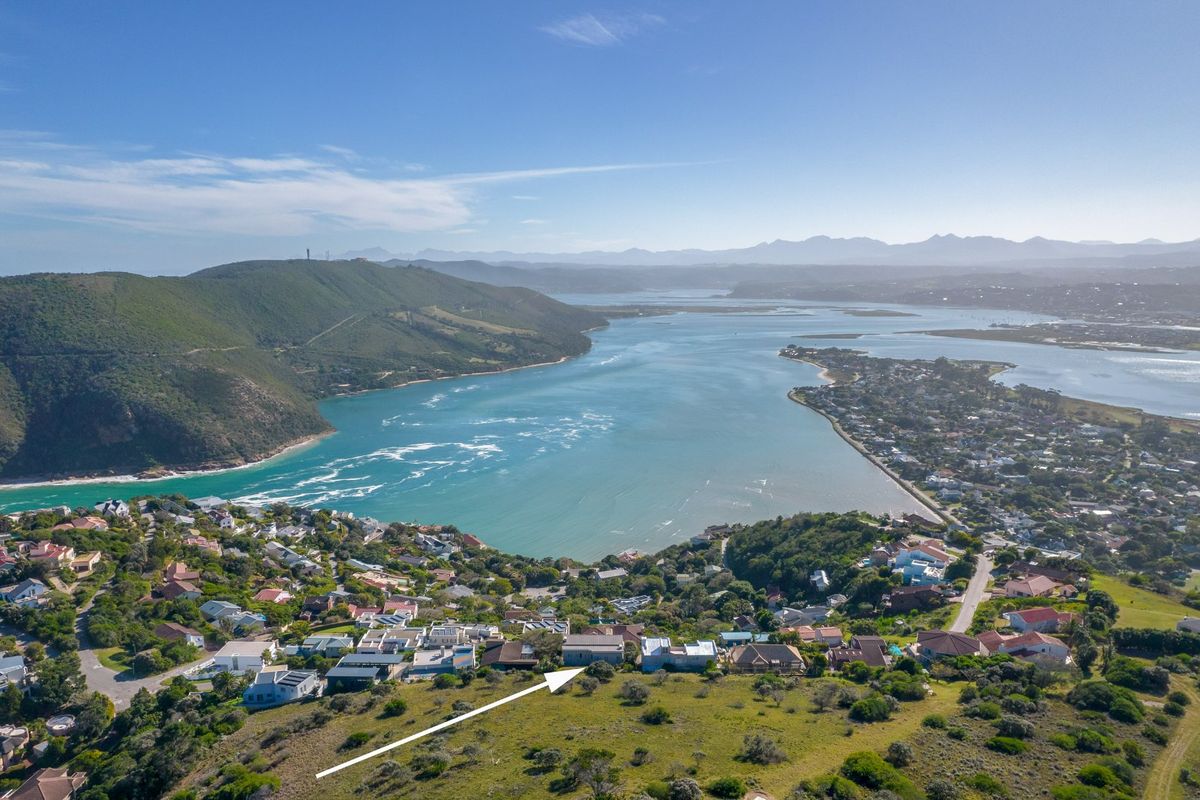 An elevated aerial view showcasing the property's location within a coastal residential estate overlooking the estuary and surrounding hills.