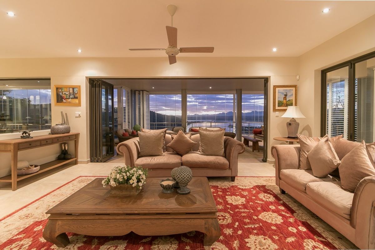 Spacious living room featuring tiled floors, recessed lighting, and large bi-fold doors opening to a scenic outdoor patio area.