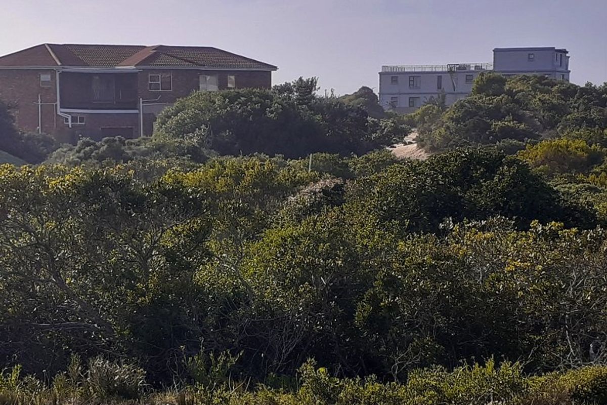 A view of the surrounding coastal landscape and neighboring residential properties from the vacant land plot.