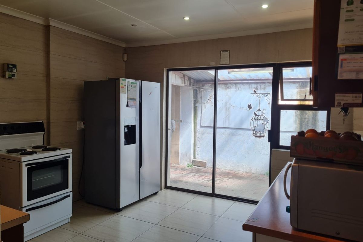 Kitchen area featuring tiled flooring, recessed lighting, and a sliding glass door providing access to an exterior courtyard area.