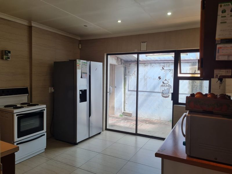 Kitchen area featuring tiled flooring, recessed lighting, and a sliding glass door providing access to an exterior courtyard area.