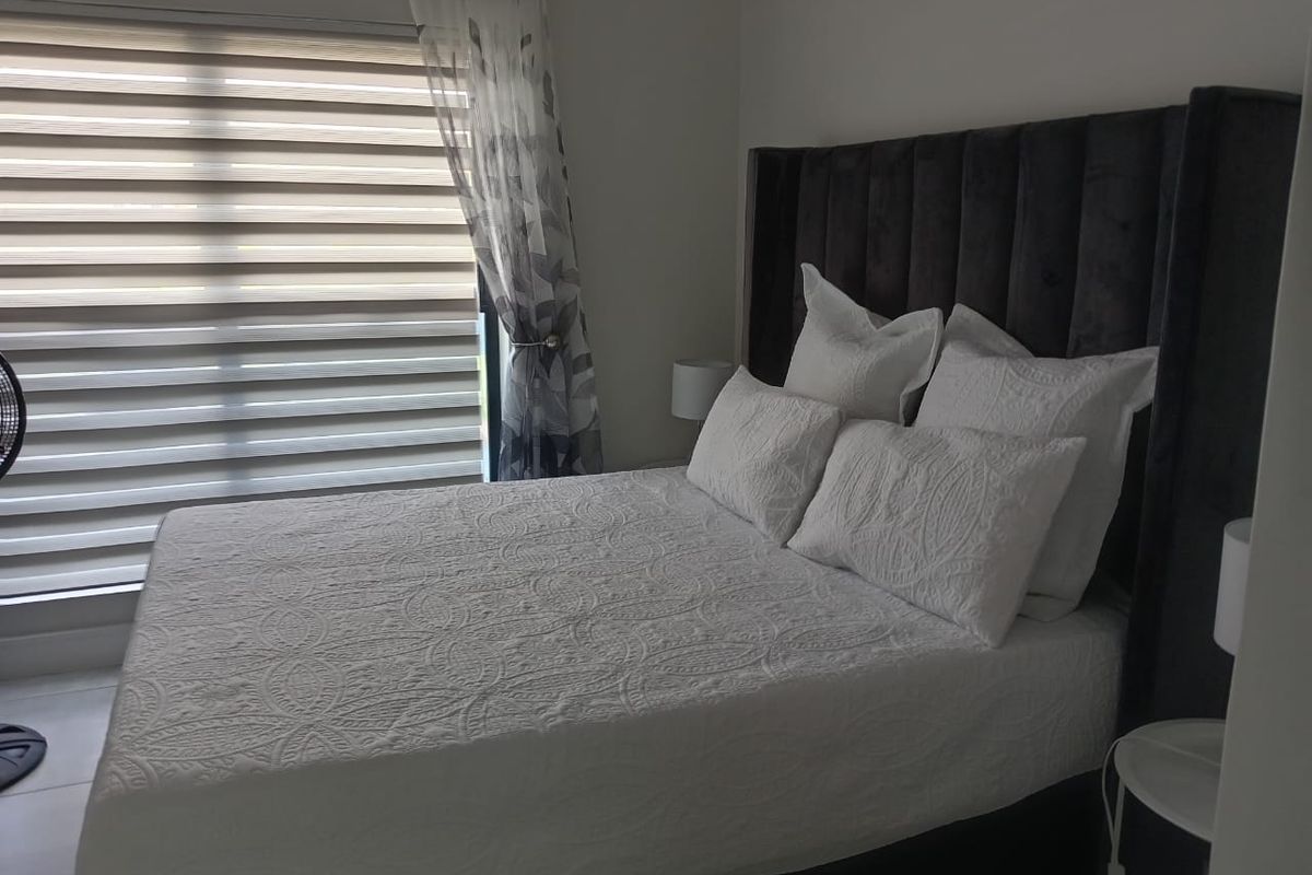 A well-maintained bedroom featuring neutral tiled flooring and modern roller blinds, providing a clean and comfortable living space.