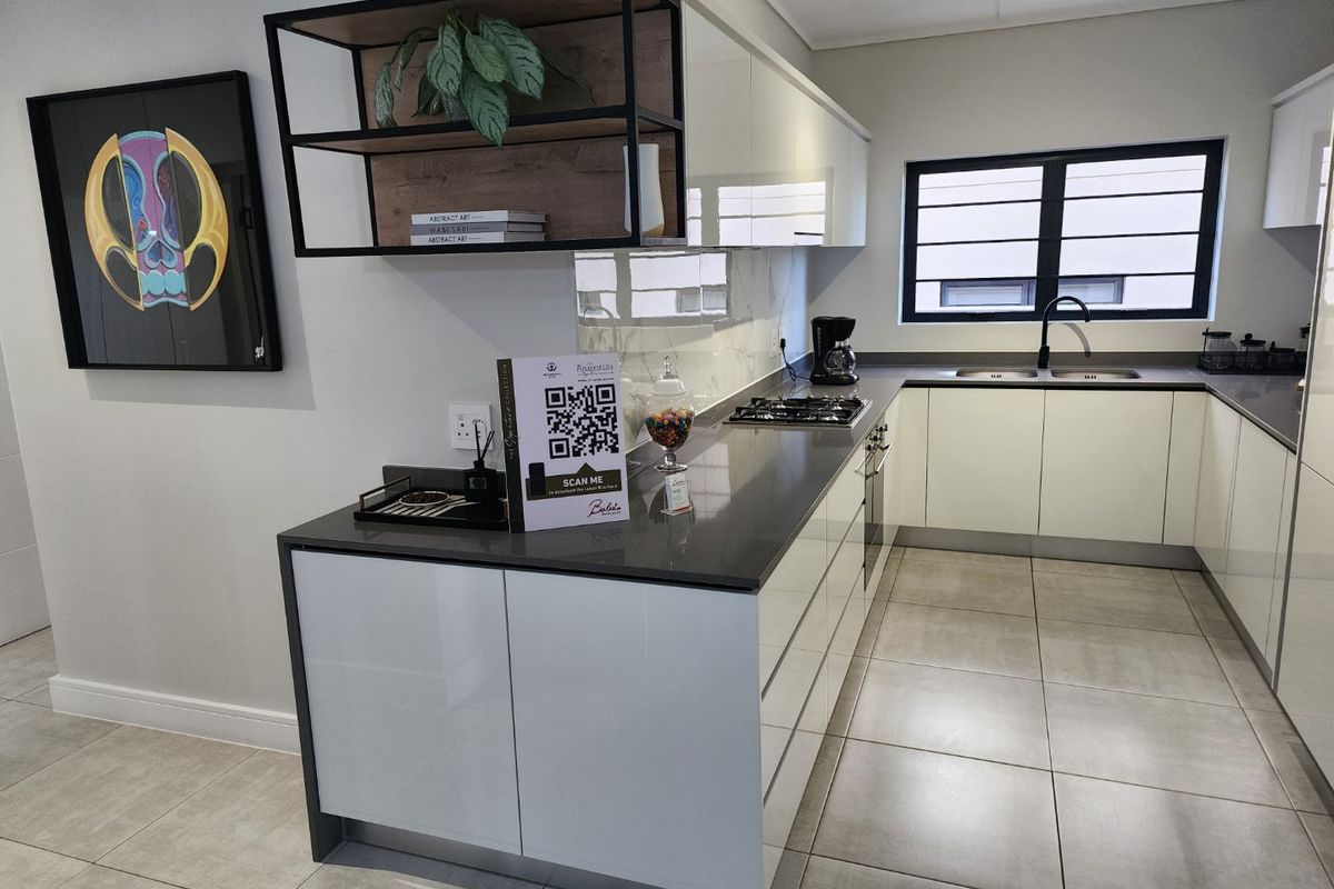 Modern kitchen featuring high-gloss cabinetry, stone countertops, a gas hob, built-in oven, and a double basin sink with a contemporary mixer tap.