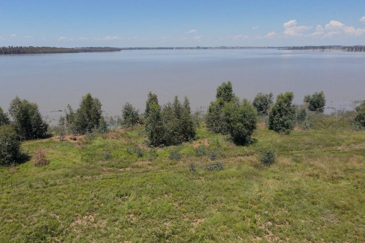 An elevated view of the vacant residential land featuring direct waterfront access and natural vegetation.