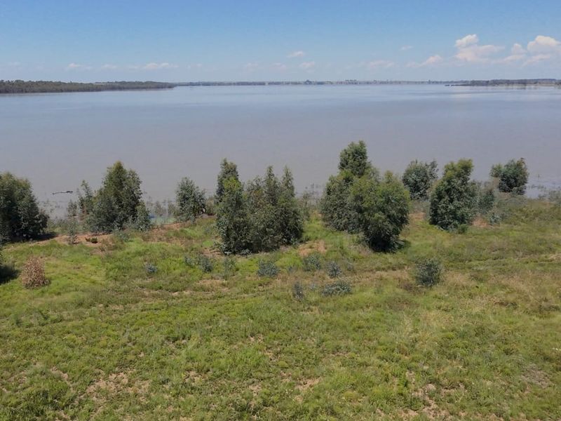 An elevated view of the vacant residential land featuring direct waterfront access and natural vegetation.