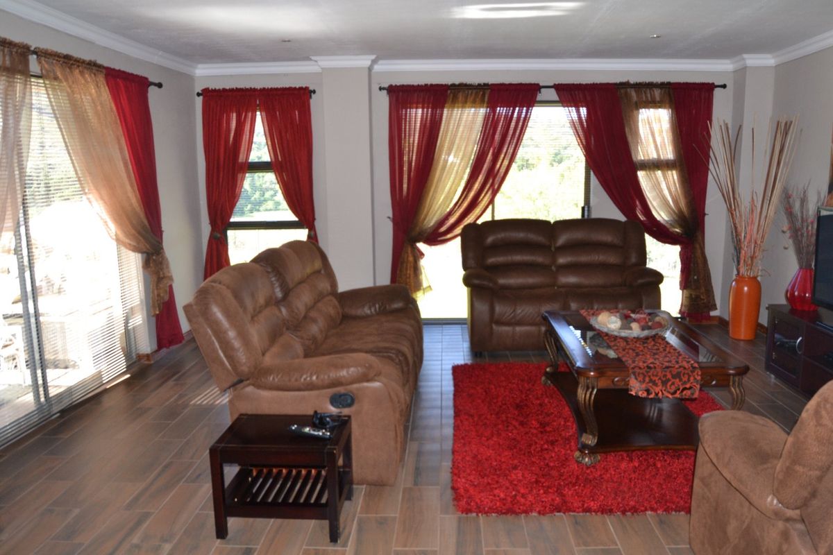 Spacious living room featuring modern wood-look tiled flooring, recessed lighting, and large sliding glass doors providing ample natural light.