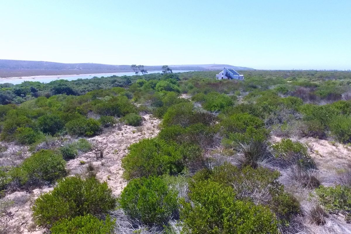 An aerial view of a vacant residential plot featuring natural coastal vegetation and proximity to the lagoon.