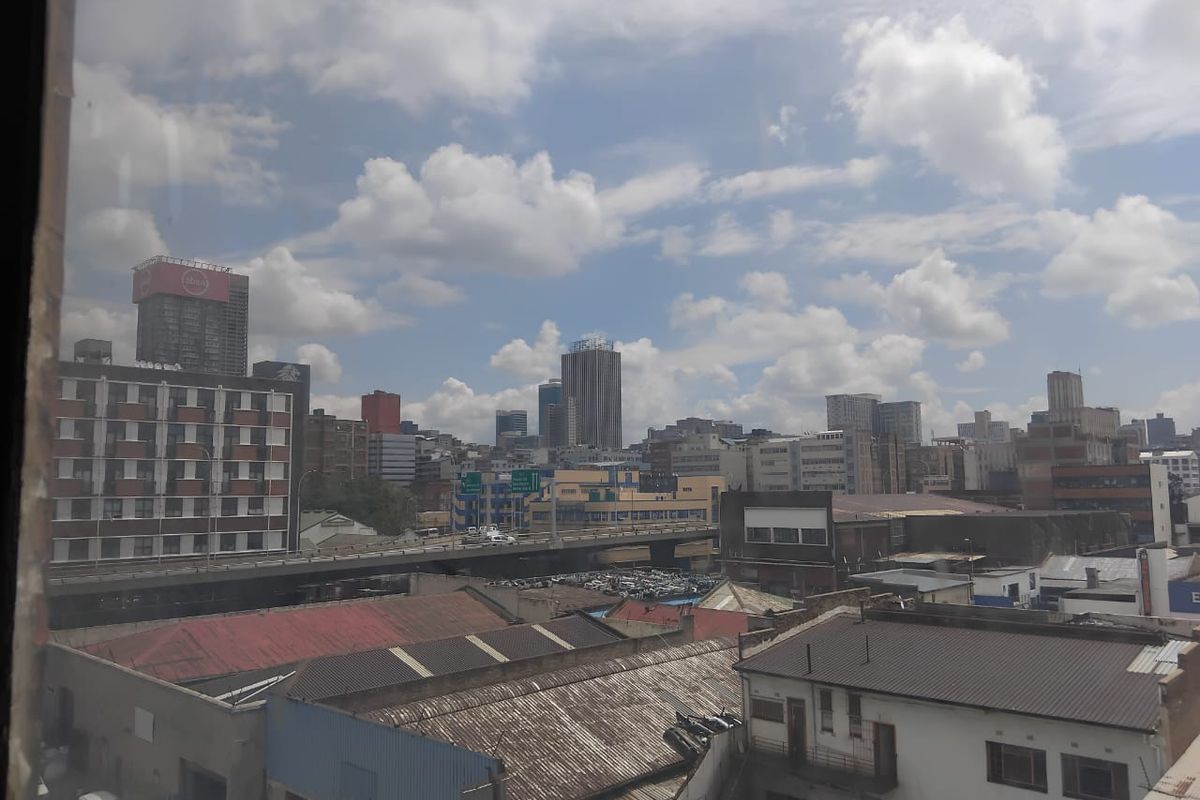 An elevated urban cityscape view looking out over surrounding commercial buildings, rooftops, and a highway overpass.