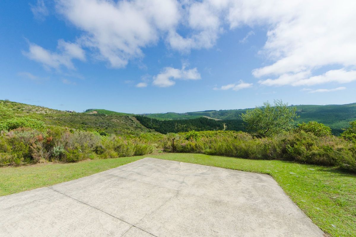 A vacant residential plot featuring a concrete pad with expansive, scenic views of the surrounding hills and natural landscape.