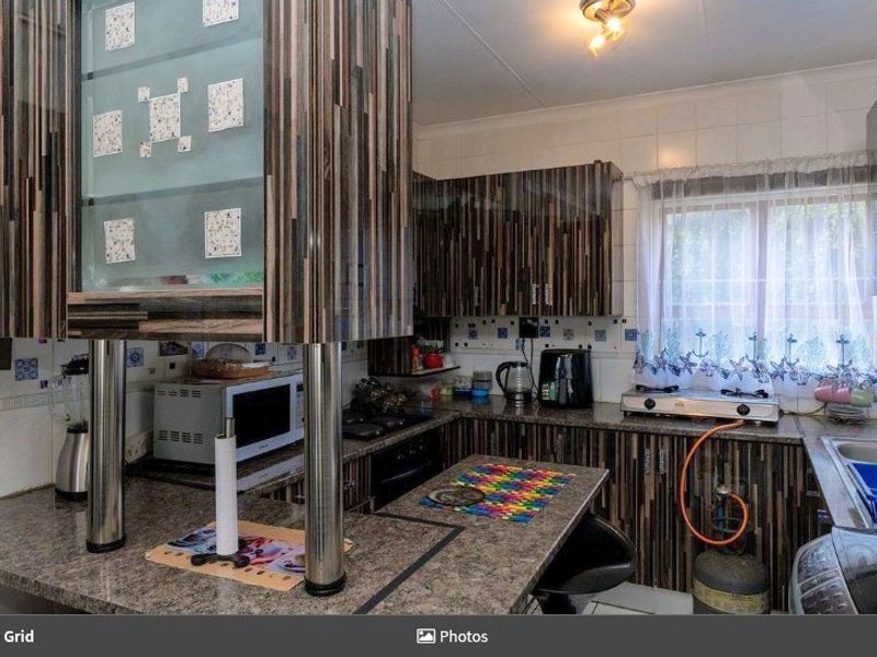 A functional kitchen featuring laminate cabinetry, granite-look countertops, a built-in oven, and a gas hob with a tiled backsplash.
