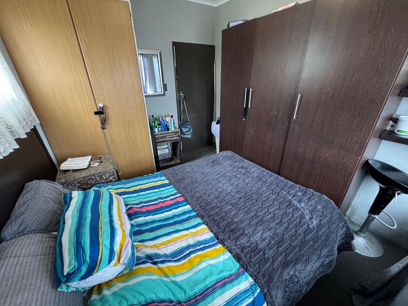 A bedroom featuring built-in wooden cupboards and a standard internal door, providing functional storage space within the room.
