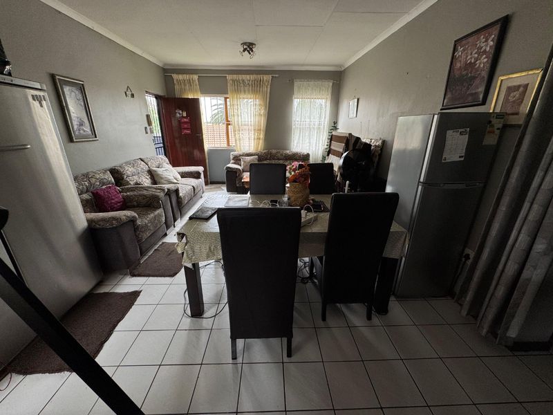 Open-plan living and dining area featuring tiled flooring and coved ceilings, providing a functional space for daily living.